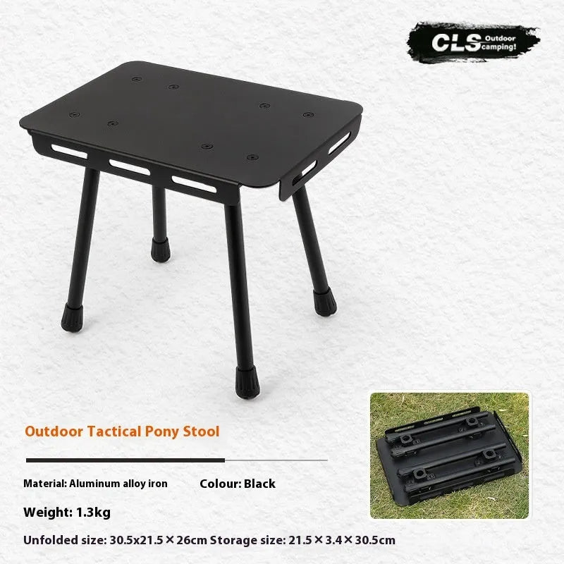 Aluminium folding camping stool that converts into a small table, shown with a tactical storage bag and a beige PU cushion.