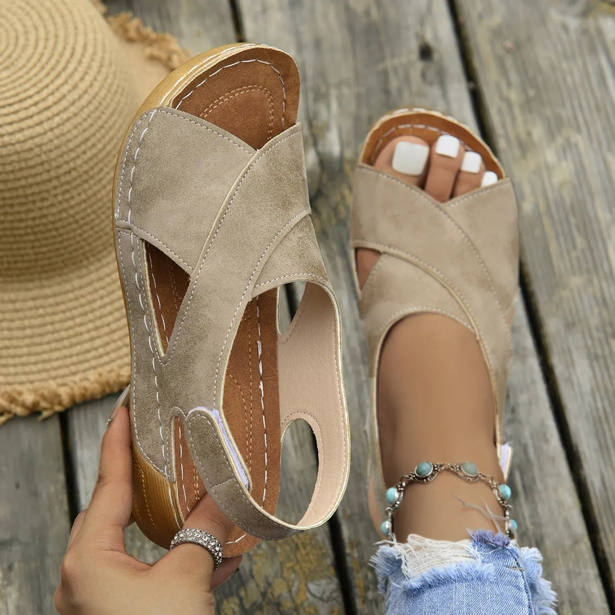 Women's brown platform Roman sandals with skirted ankle strap and Velcro fastening on a white background.