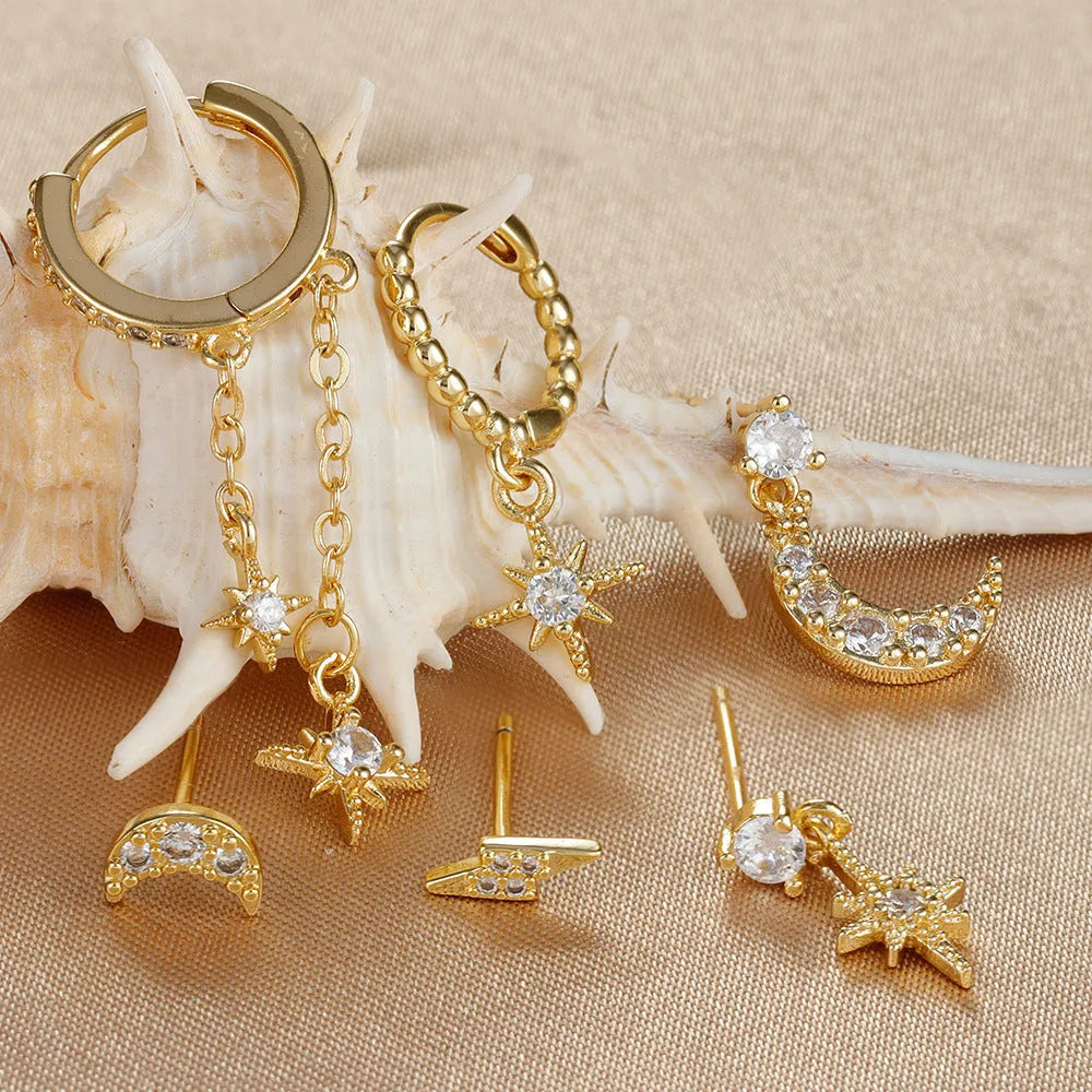 Six pairs of gold chain tassel earrings with zircon studs displayed together
