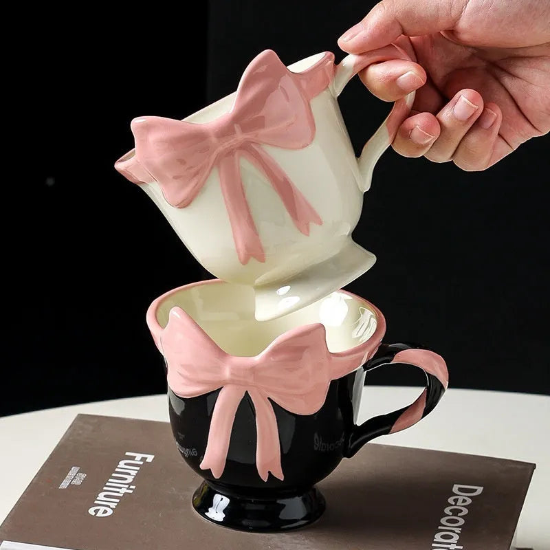 Ceramic mug with heart bow design in cute style showing Black Pink and White Powder colour options
