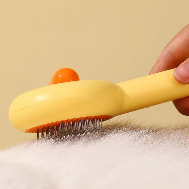 Small yellow duck-shaped pet grooming comb with needle pins for cats and small dogs