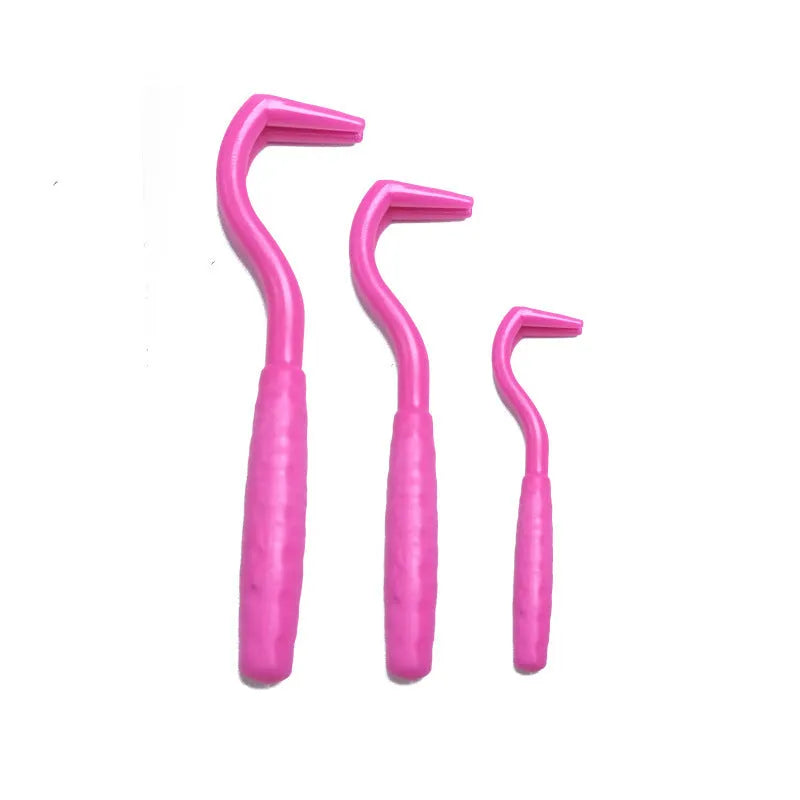 Set of three coloured tick hook removers for dogs on a white background.