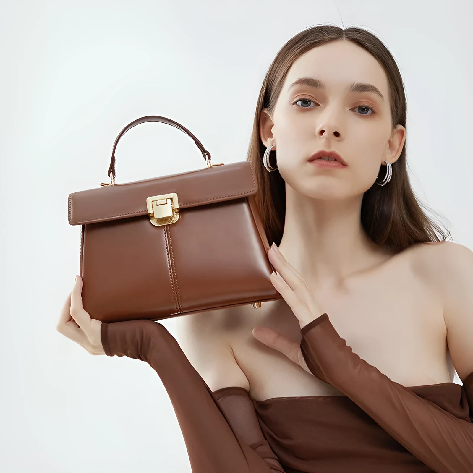 Women's black genuine leather shoulder bag with vachette clasp closure showing horizontal square design
