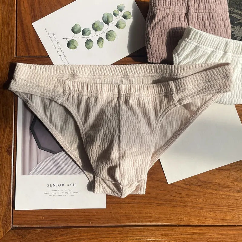 Men's solid colour cotton triangle briefs with a mid-waist waistband on a white background.