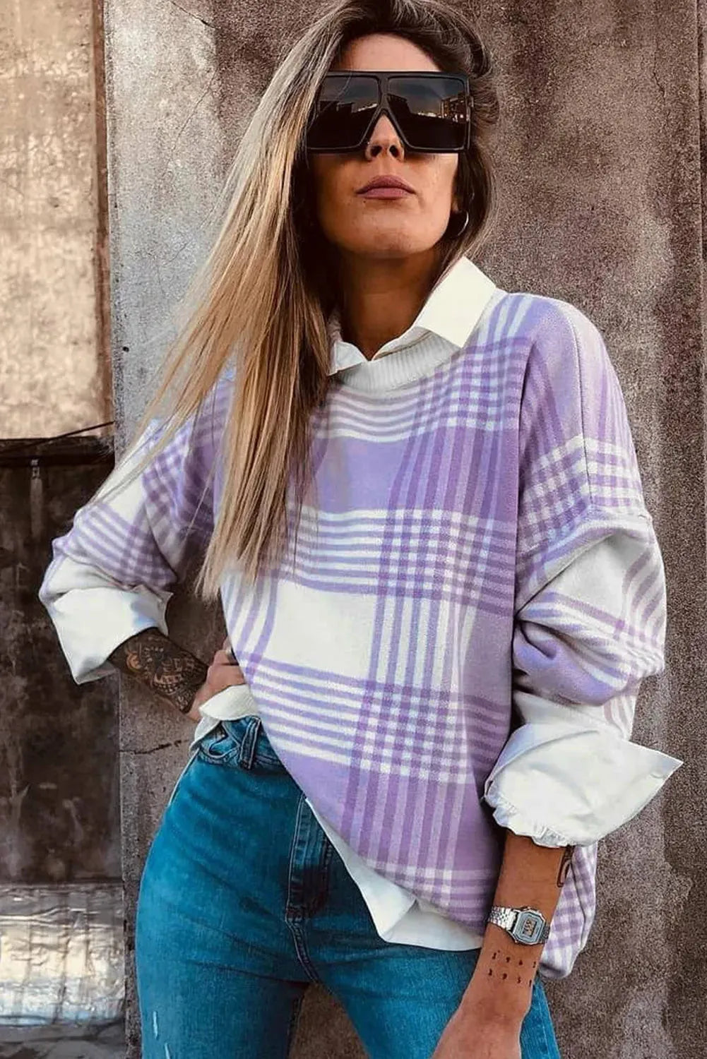 Lilac plaid print loose fit long sleeve sweater with ribbed cuffs on a hanger.