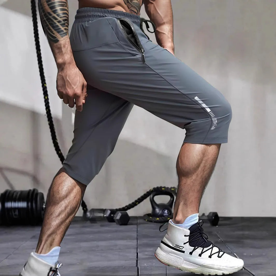 Man wearing grey cropped straight-leg casual sports pants made from quick-dry nylon fabric.
