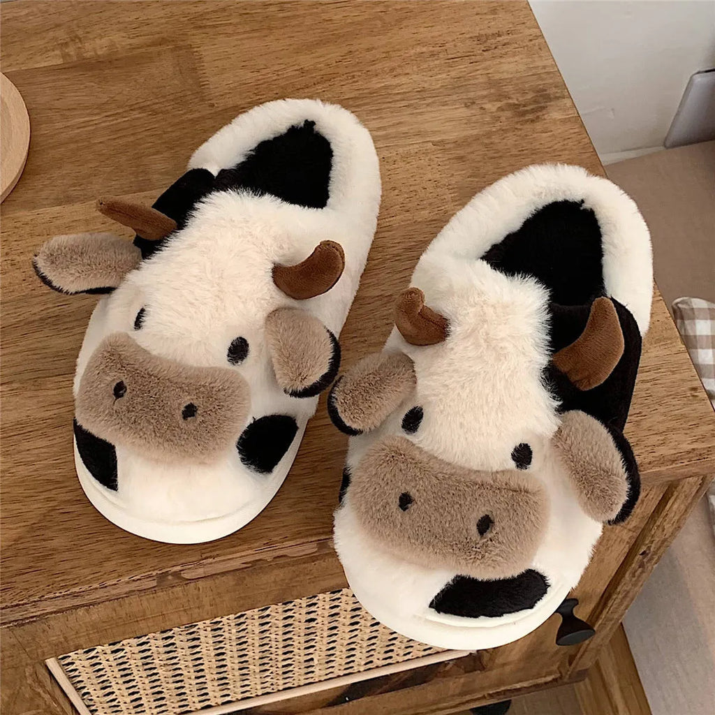 White plush cow slippers for women with a non-slip textured sole.