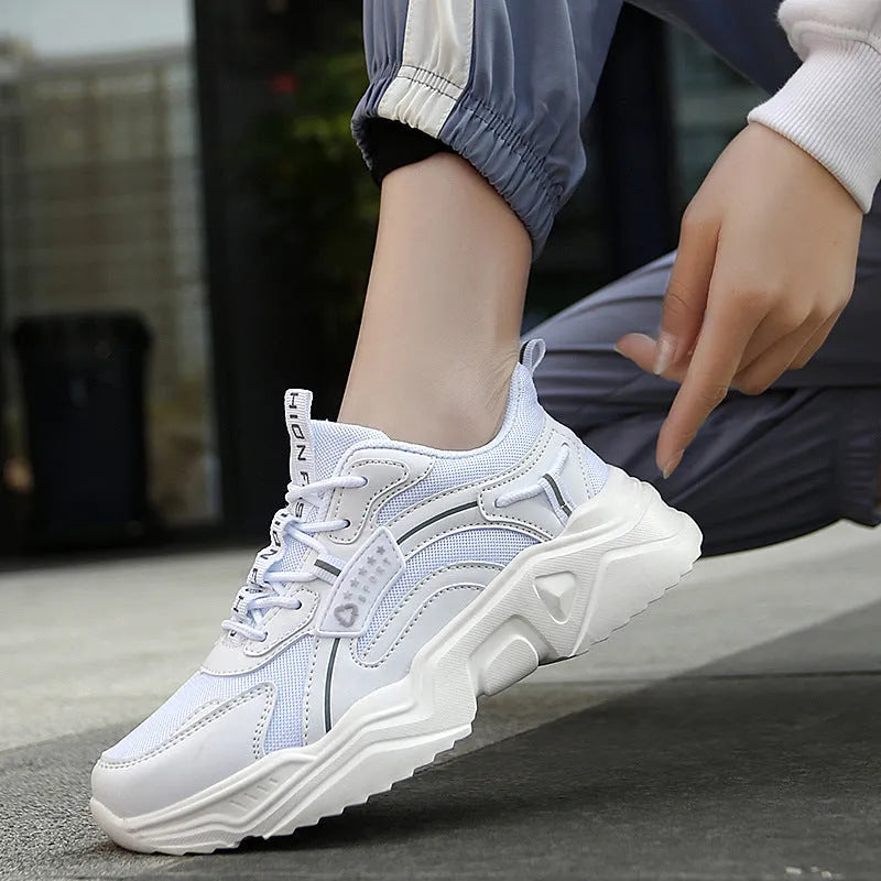 Women's white thick-soled casual sports shoes with mesh upper and buckle detail.