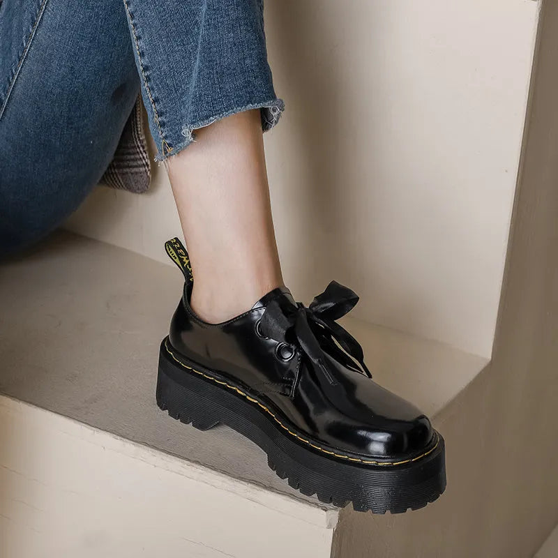 Women's black and white thick-soled leather shoes with lace-up closure and decorative straps
