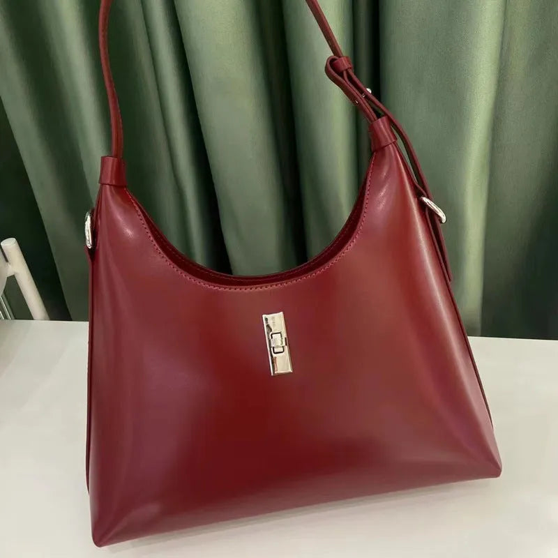 A soft genuine leather dumpling-shaped crossbody shoulder bag in a street style, shown with internal phone pocket.
