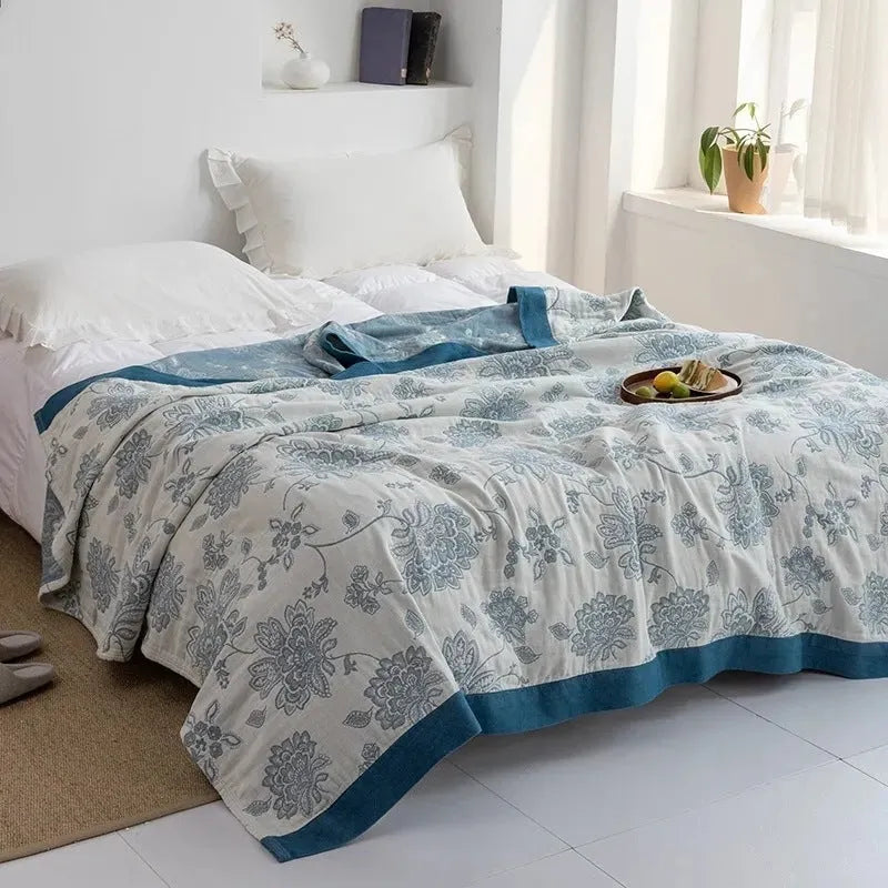 Blue five-layer gauze pure cotton blanket folded to show texture and modern printed pattern.
