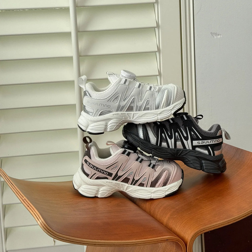 Pair of beige unisex casual shoes with PU leather mesh uppers on a plain background.