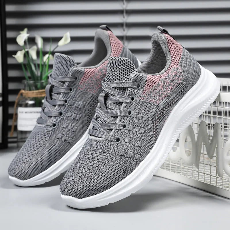Women's low-top black mesh sneakers with round toe and white PVC sole, shown with lace-up front.
