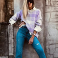 Lilac plaid print loose fit long sleeve sweater with ribbed cuffs on a hanger.