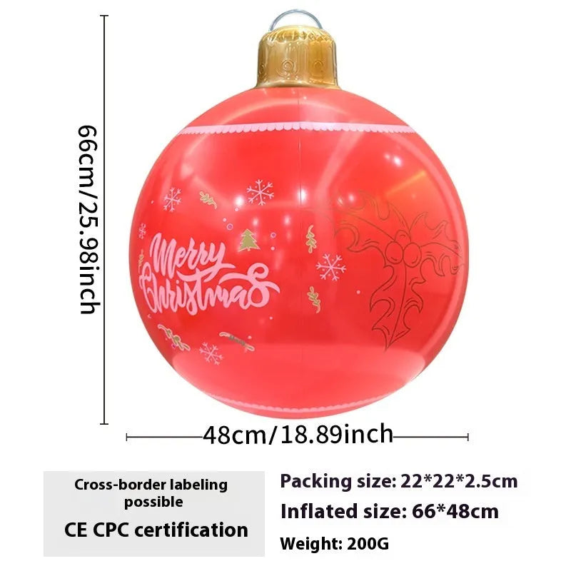 Large red inflatable Christmas ball with snowflake pattern and flash light, shown with a hand pump in a garden setting.