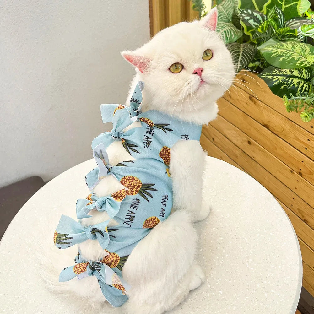 Cat wearing a pink lace-up polyester sterilisation suit after surgery, showing the adjustable tie closure.