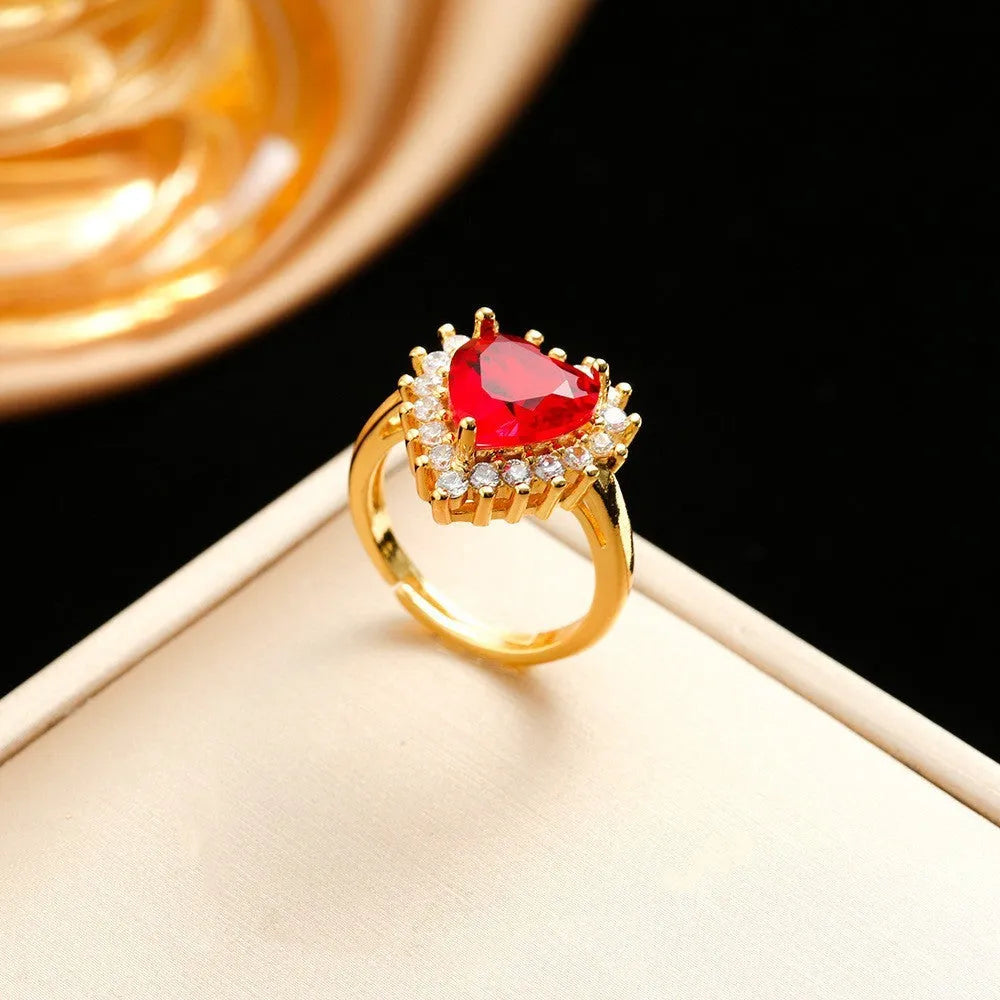 Gold red titanium steel jewellery set with heart flower pendant, matching earrings, and ring on a water wave chain.