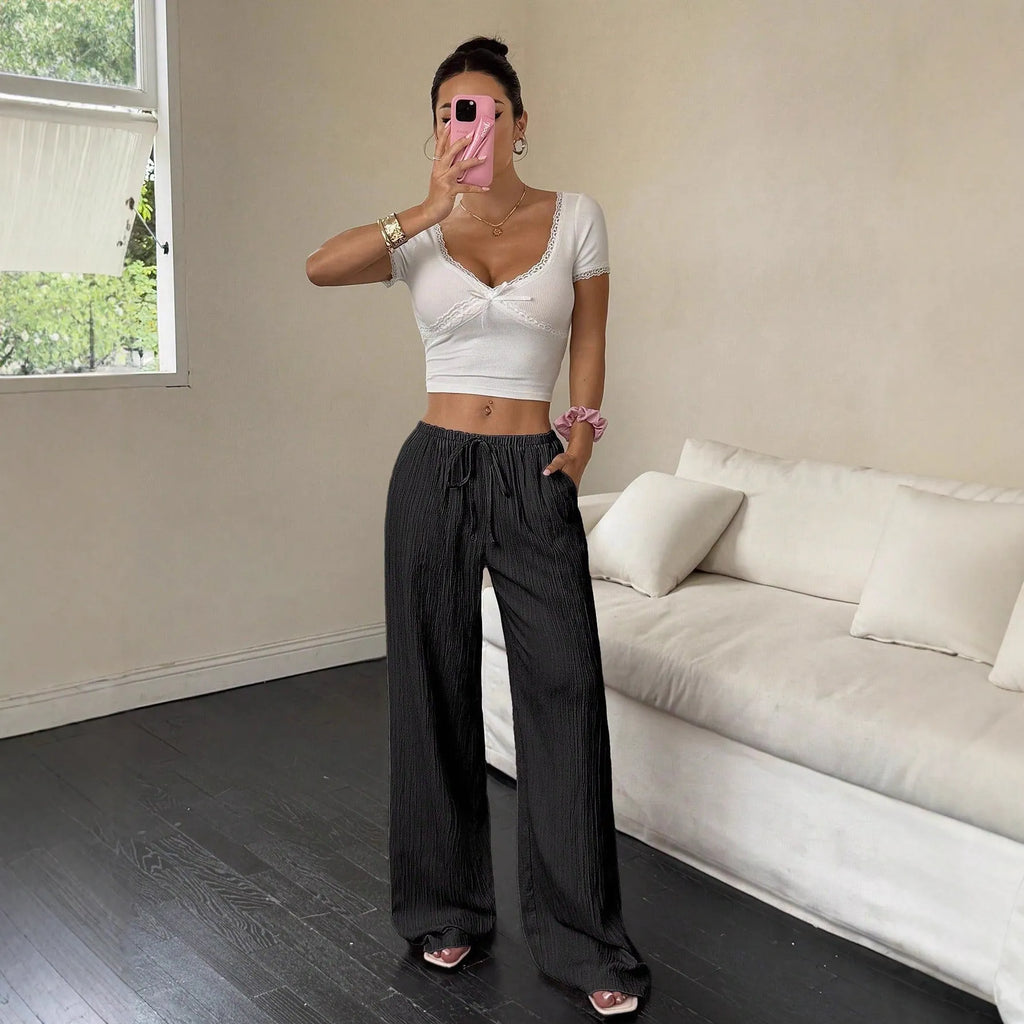 Women's black wide leg trousers with lace-up waist detail, shown with pink colour option