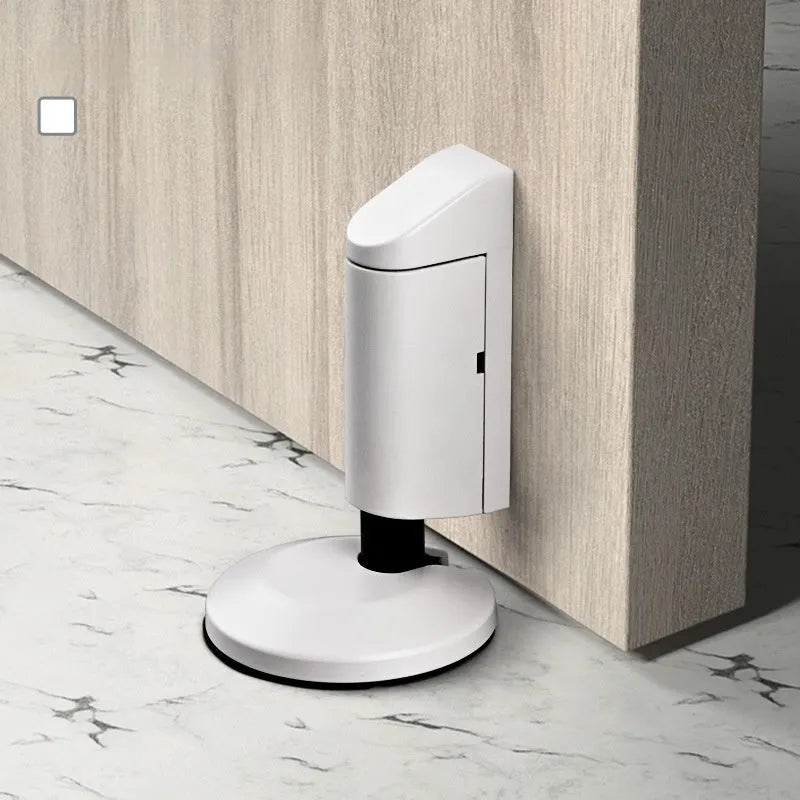 Modern zinc alloy invisible door stopper in brushed nickel finish on a wooden floor.