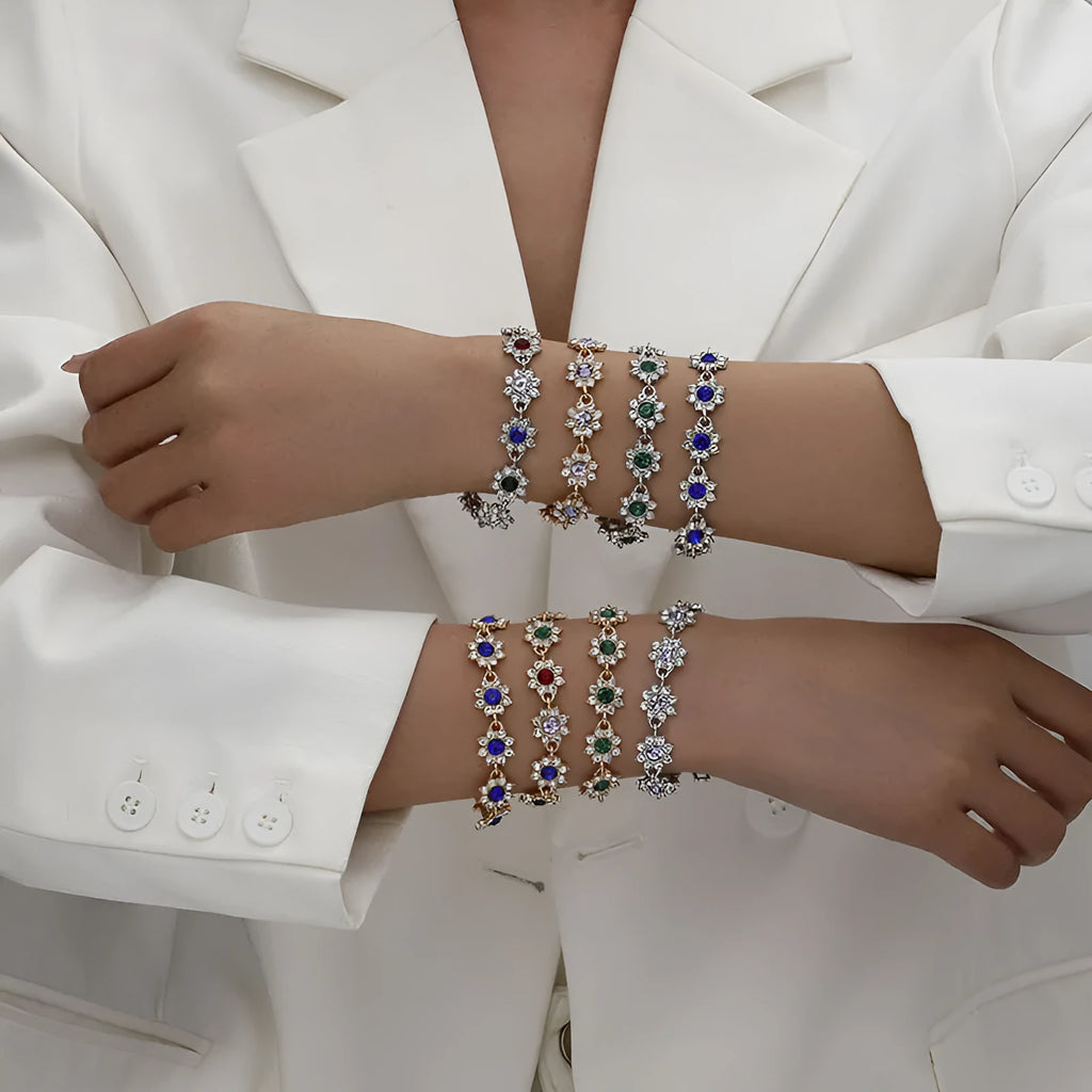 A gold or silver electroplated zinc alloy flower bracelet with coloured gems.