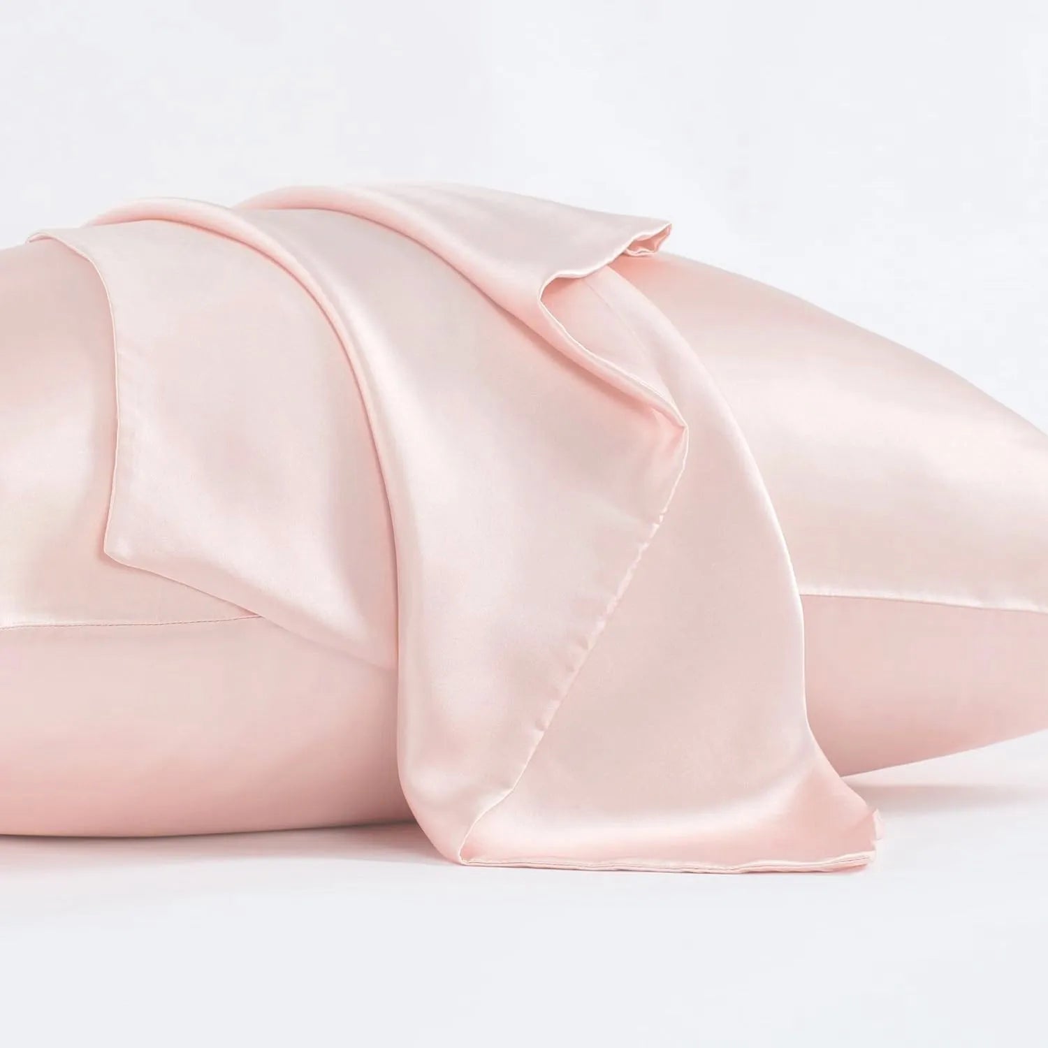 Dark grey mulberry silk pillowcase with an envelope closure on a bed.