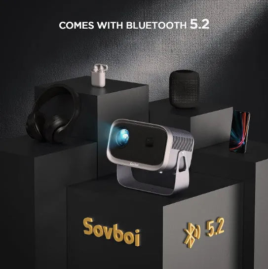 White portable Android smart projector on a table, showing a phone screen mirrored onto a wall displaying a movie scene.