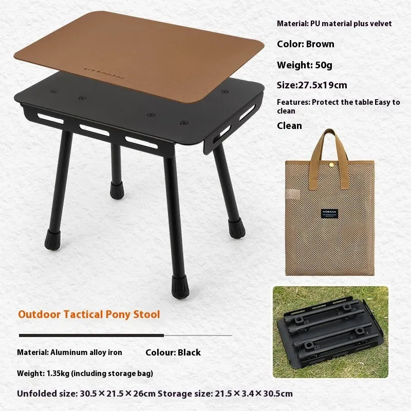 Aluminium folding camping stool that converts into a small table, shown with a tactical storage bag and a beige PU cushion.