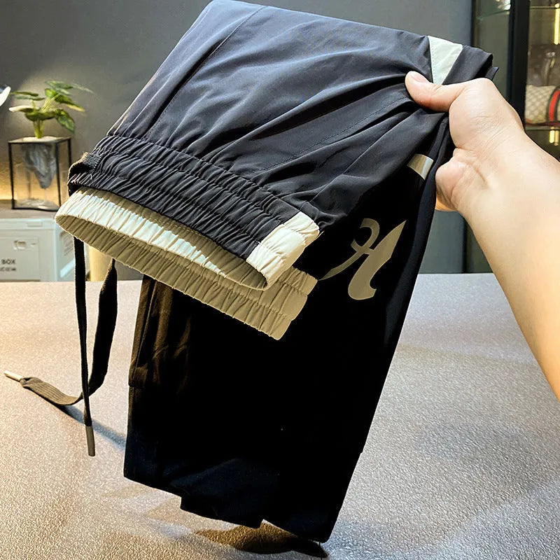 Black men's cropped casual trousers with ankle band, made from ice silk cotton fabric.