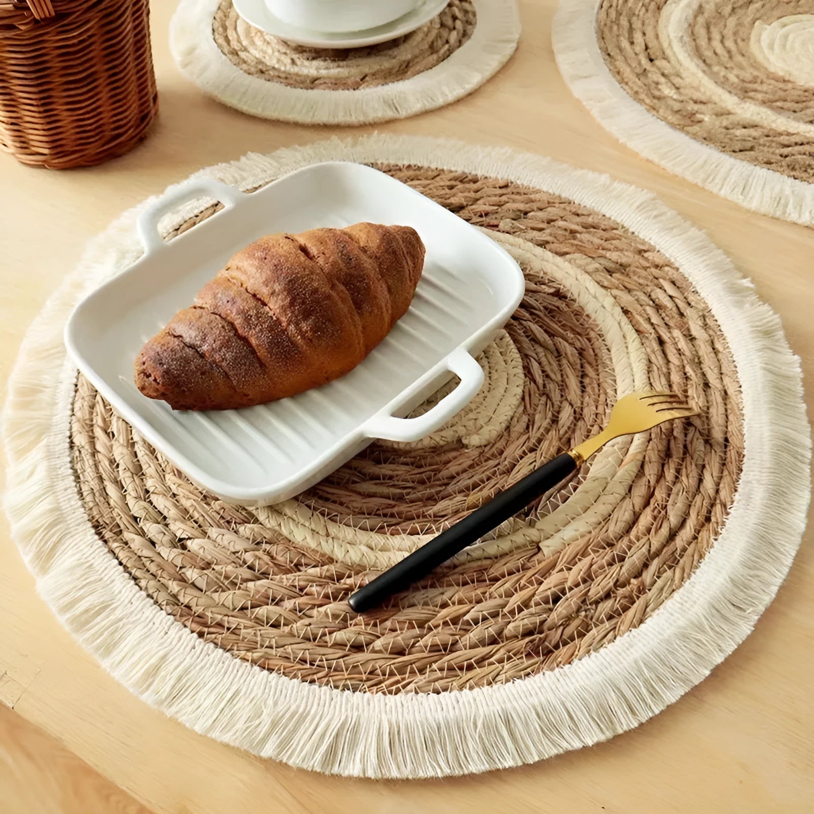 Round natural papyrus placemat with decorative tassels on a wooden table, shown in various sizes.
