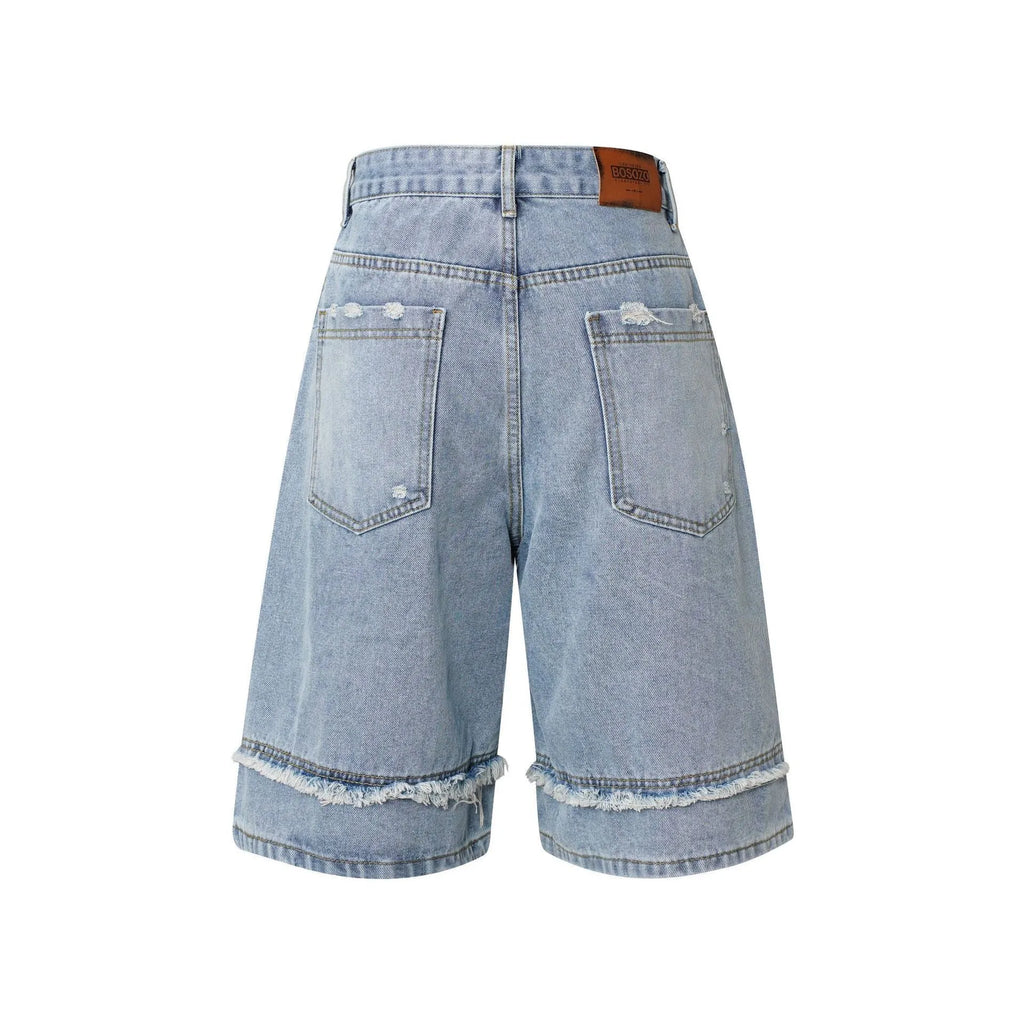 Distressed denim shorts with raw edge hem in light blue, laid flat to show straight leg cut.