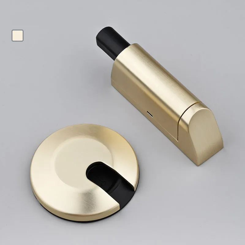 Modern zinc alloy invisible door stopper in brushed nickel finish on a wooden floor.