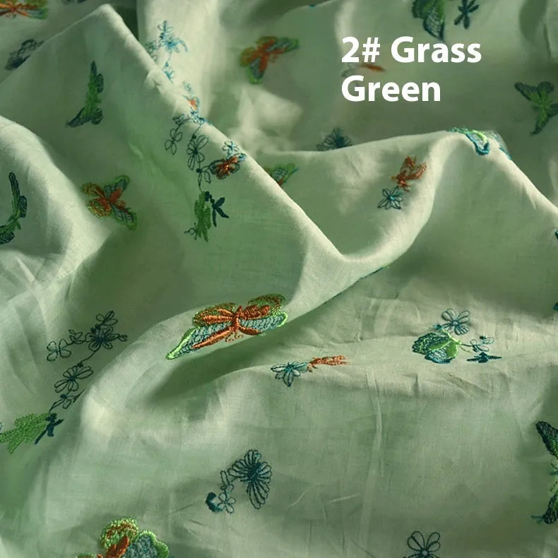 Roll of beige, grass green and dark green 100% ramie fabric for Hanfu sewing and embroidery, showing texture.