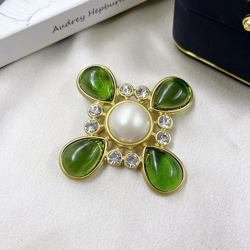 A vintage-style zinc alloy brooch with a baroque cross design and crystal accents.