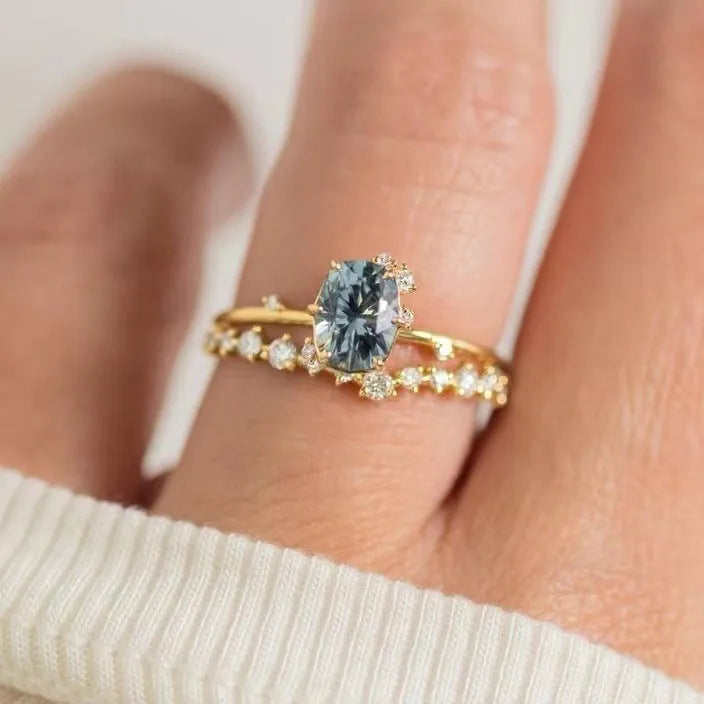 Gold electroplated floral-shaped alloy ring with a green zircon inlay on a white background.