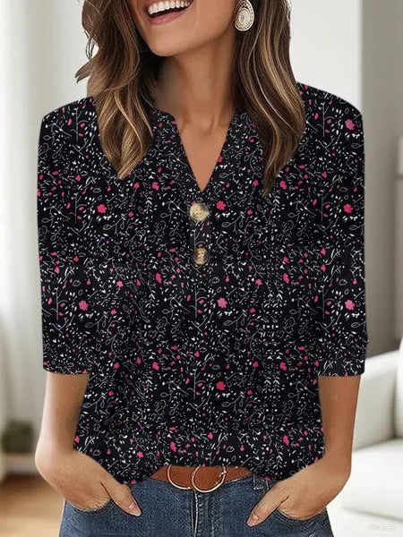 Woman wearing a loose V-neck T-shirt with a bold 3D pattern print in casual style.