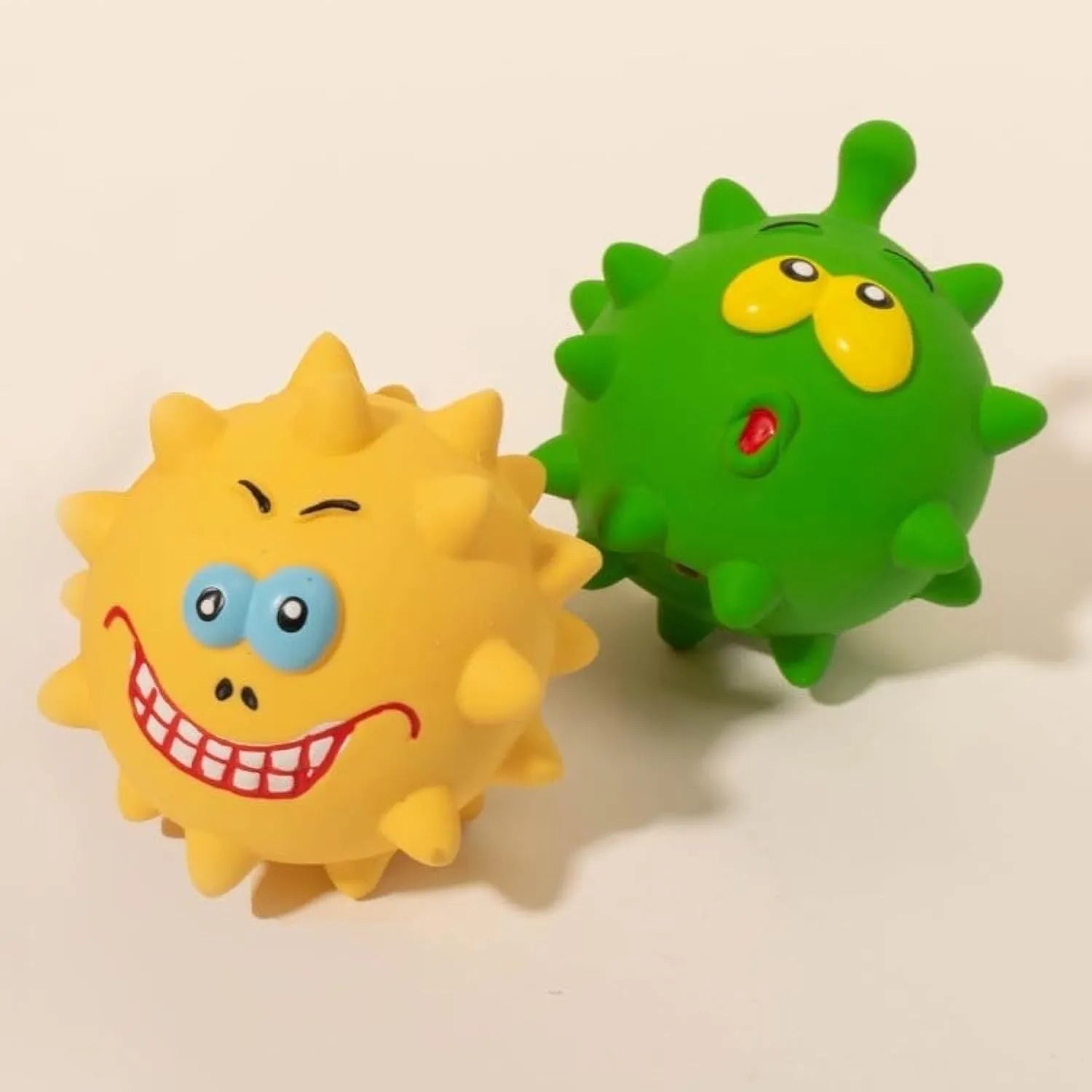 Four coloured natural latex squeaky dog balls with cute faces, each measuring 7.5cm