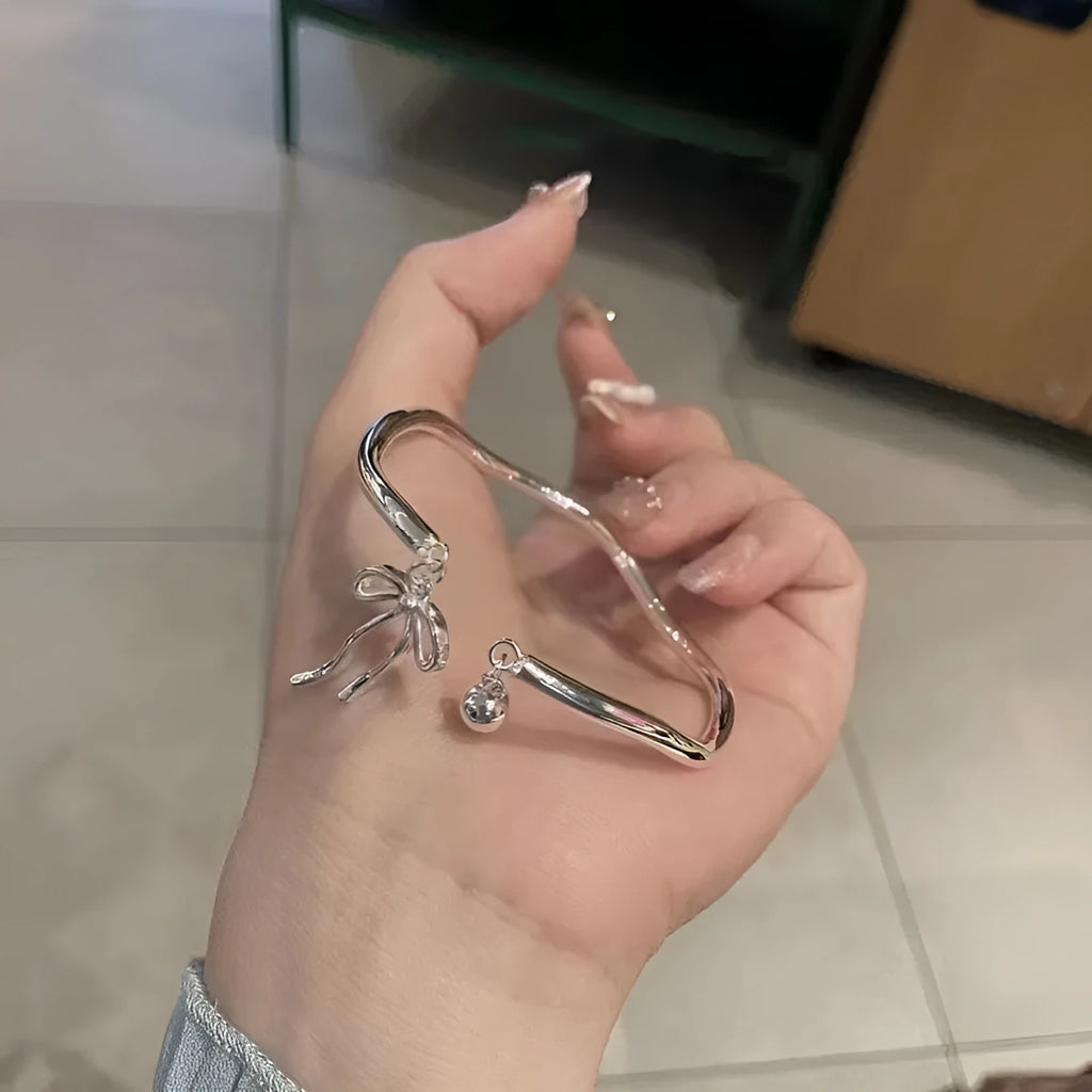 Silver bow-shaped adjustable bracelet made of electroplated zinc alloy with opening band design