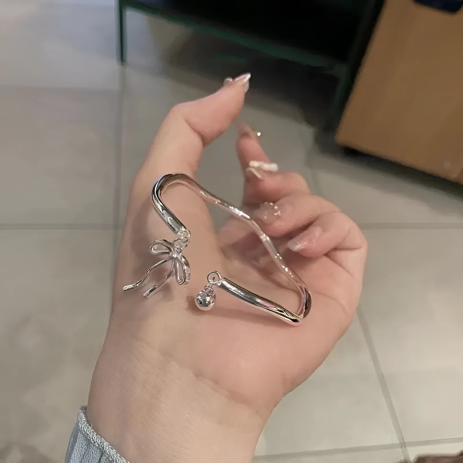 Silver bow-shaped adjustable bracelet made of electroplated zinc alloy with opening band design