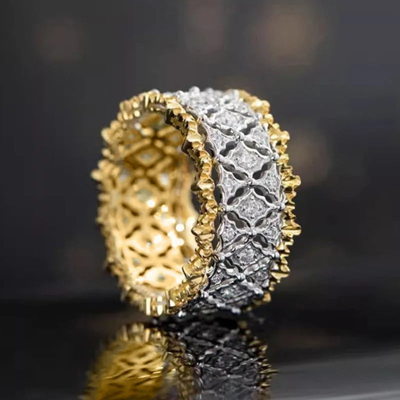 Gold two-tone copper ring with round geometric zircon centrepiece on a plain background.