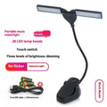 Rechargeable black music stand light with 28 lamps and USB cable on a music stand.