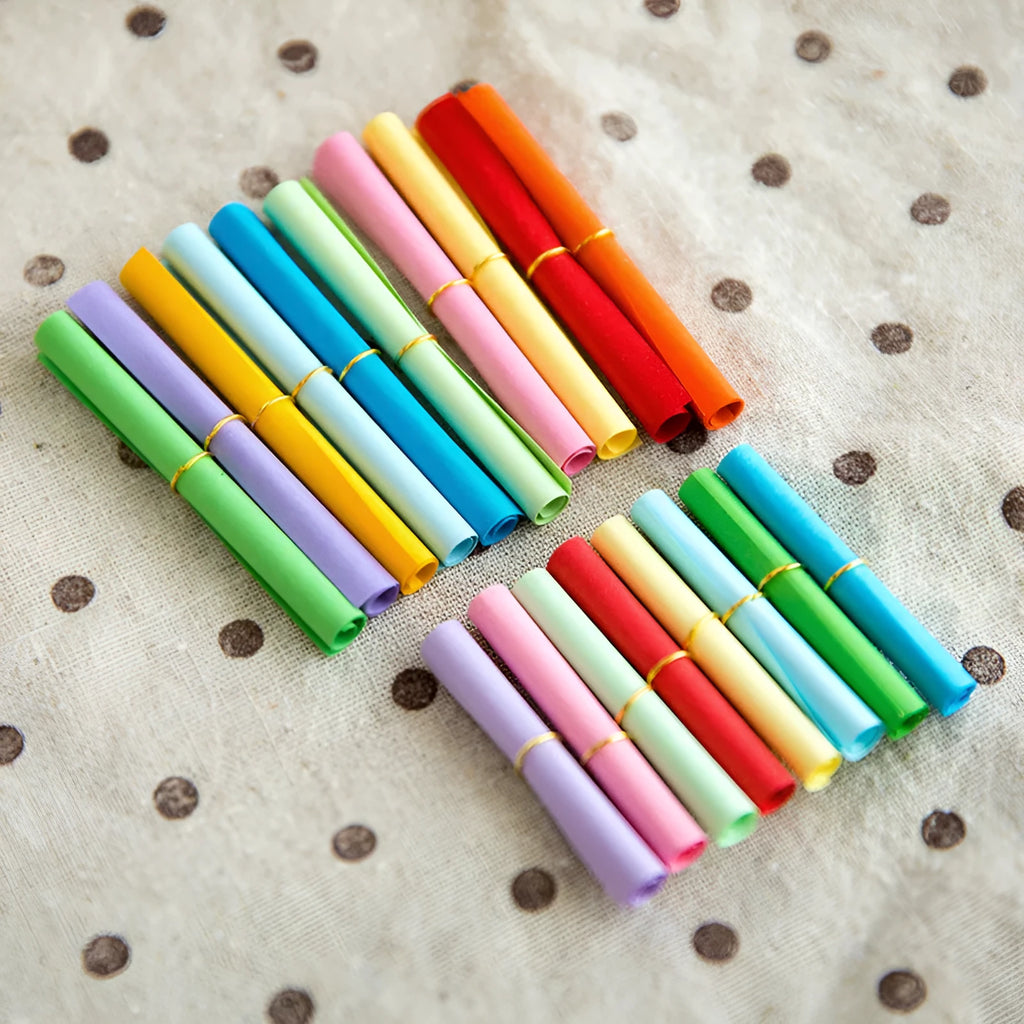 Colourful assortment of small paper scrolls with metal eyelets for drift bottle messages.