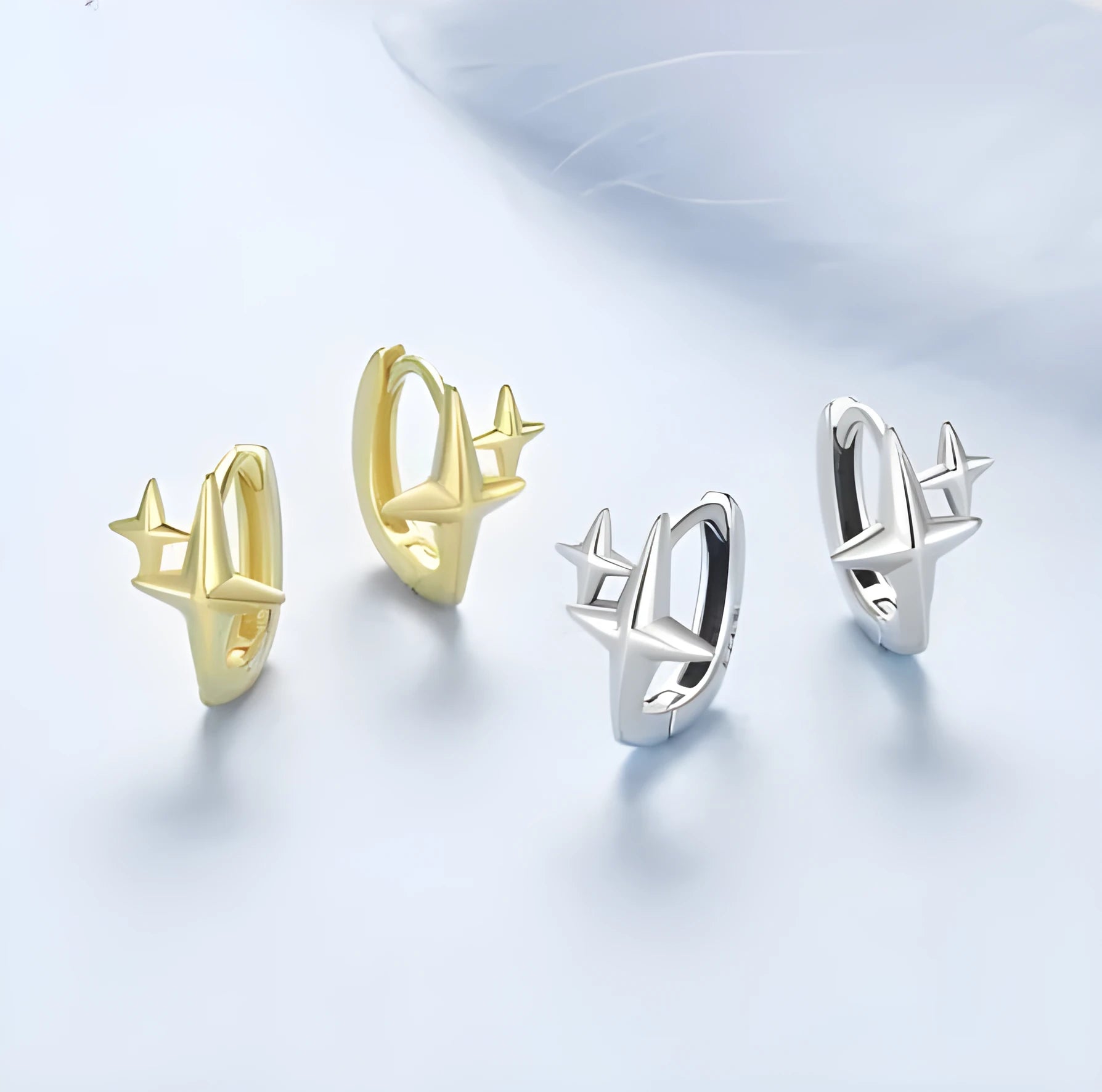 Minimalist oxidised sterling silver star clip-on earrings with XINGX detail on a white background.