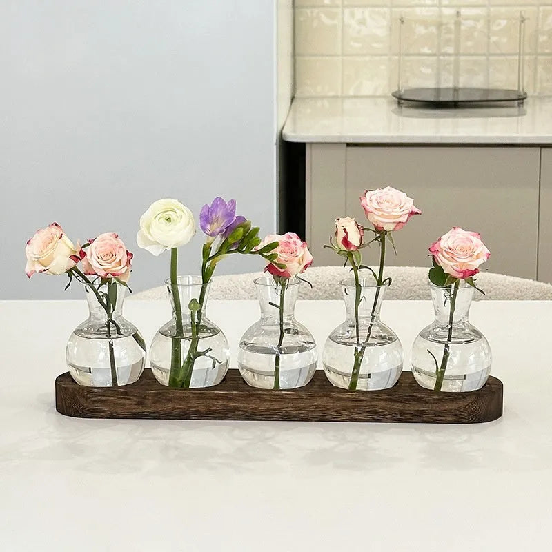 Wooden frame holding transparent glass hydroponic vases in modern home setting
