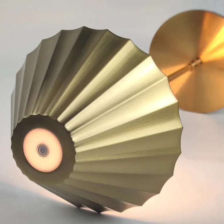 Gold alloy desk lamp with a fabric shade on a wooden table