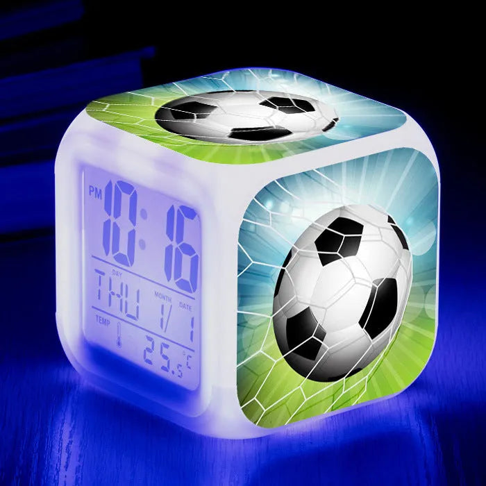 Square plastic alarm clock with football pattern design showing four alarm settings and USB charging port
