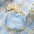 Small dog wearing heart pattern vest with bow suspenders in blue colour, showing elastic fit and decorative design