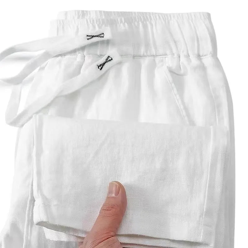Man wearing apricot-coloured straight leg linen trousers with a drawstring waist.