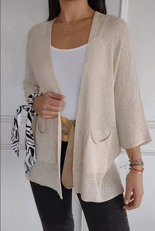 Women's thin waffle weave cardigan coat in army green with pockets, shown on a hanger.