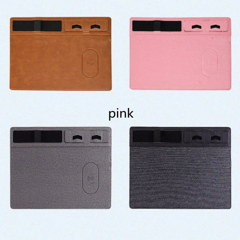 Pink PU leather wireless charging mouse pad with integrated phone holder on a desk.