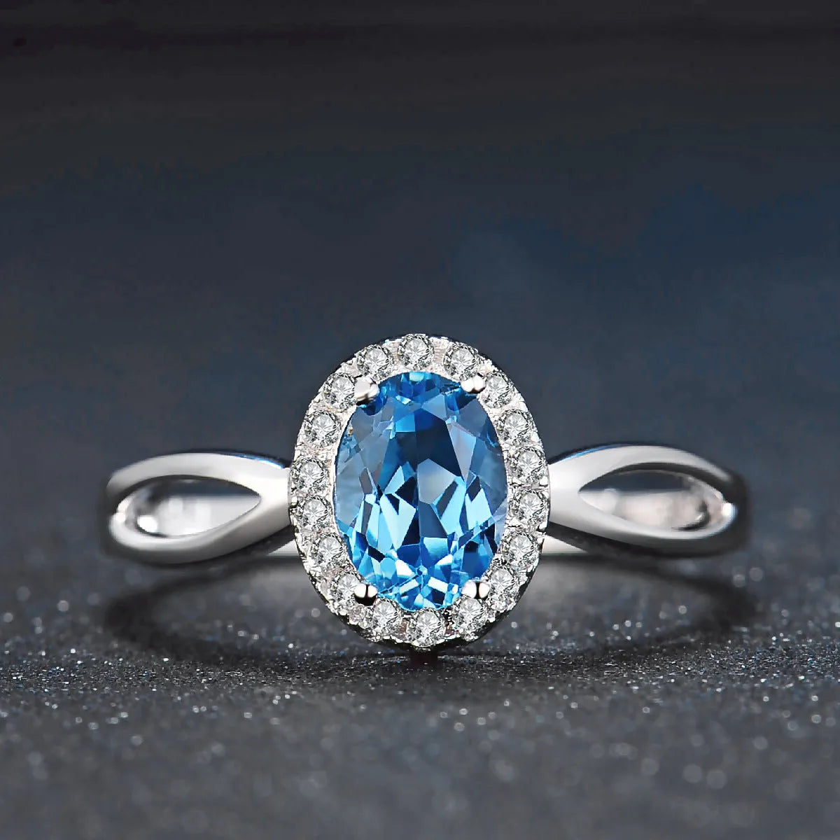 Four-piece 925 Sterling Silver geometric jewellery set with blue topaz gems, showing earrings, ring, pendant, and necklace.